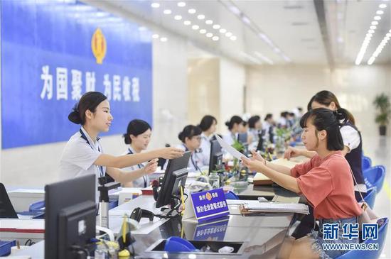  國家稅務(wù)總局泉州市稅務(wù)局豐澤街辦稅服務(wù)廳的工作人員在新辦企業(yè)服務(wù)窗口為納稅人提供“套餐式”服務(wù)（2018年9月13日攝）。新華社記者 宋為偉 攝